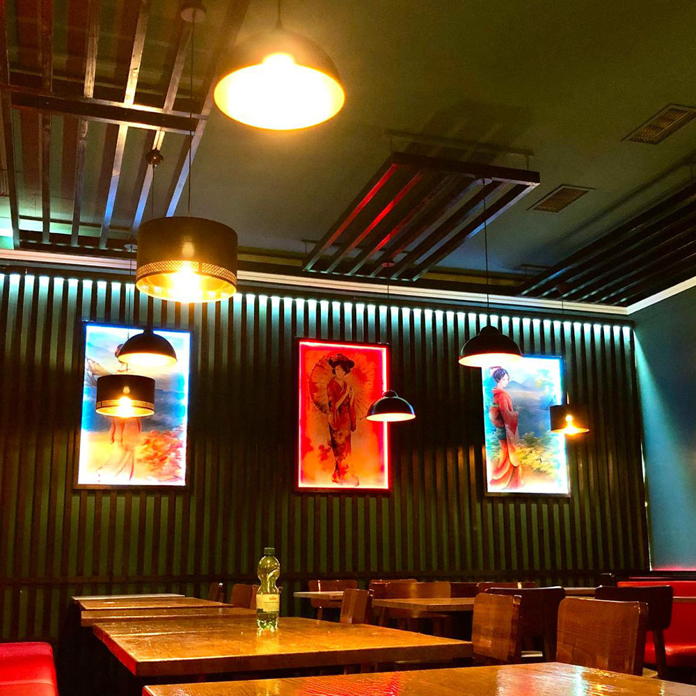 Ein stilvoll eingerichtetes Restaurant mit künstlerischen Wandbildern und schummrigem Licht.