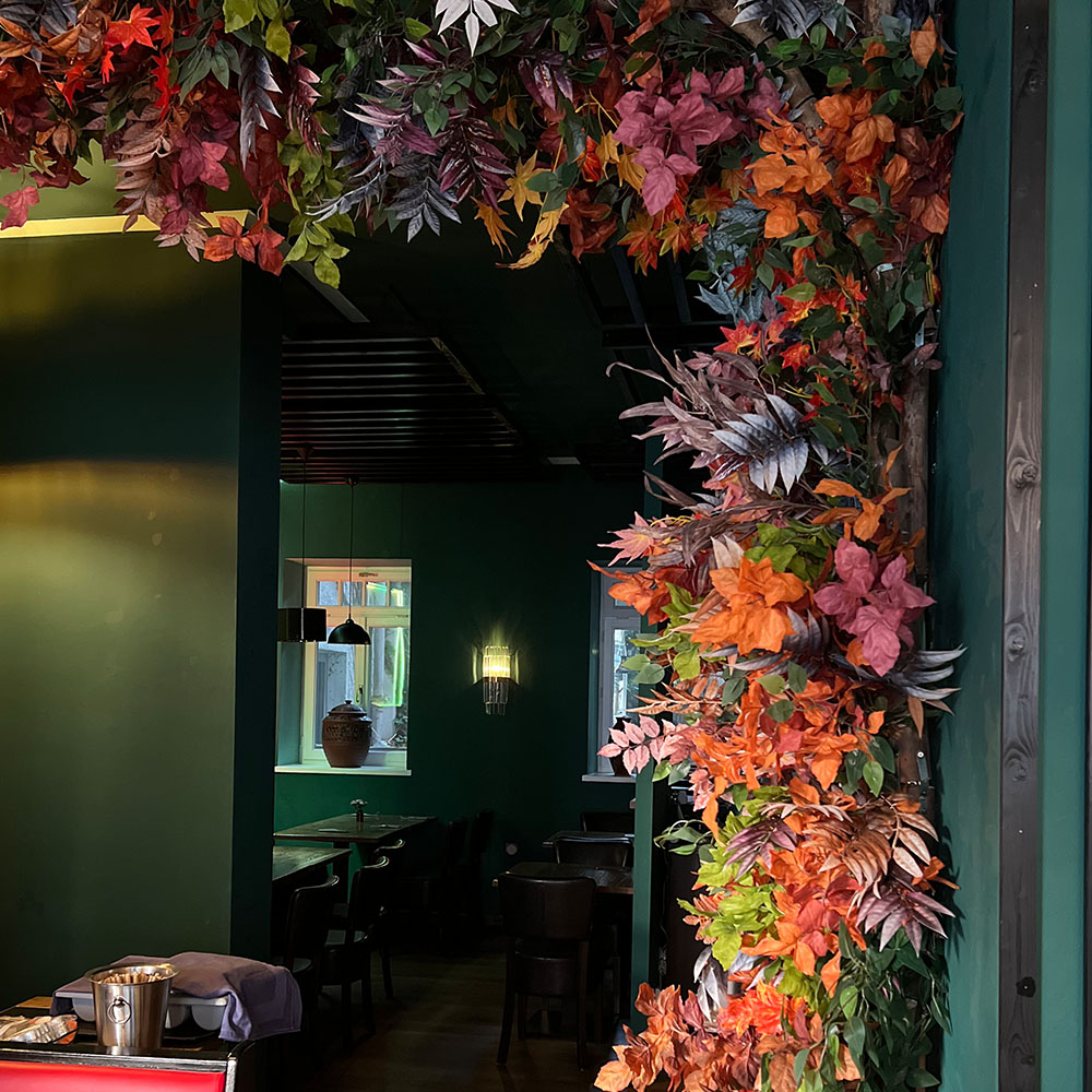 Eine Ecke eines Raumes ist mit bunten Herbstblättern dekoriert.