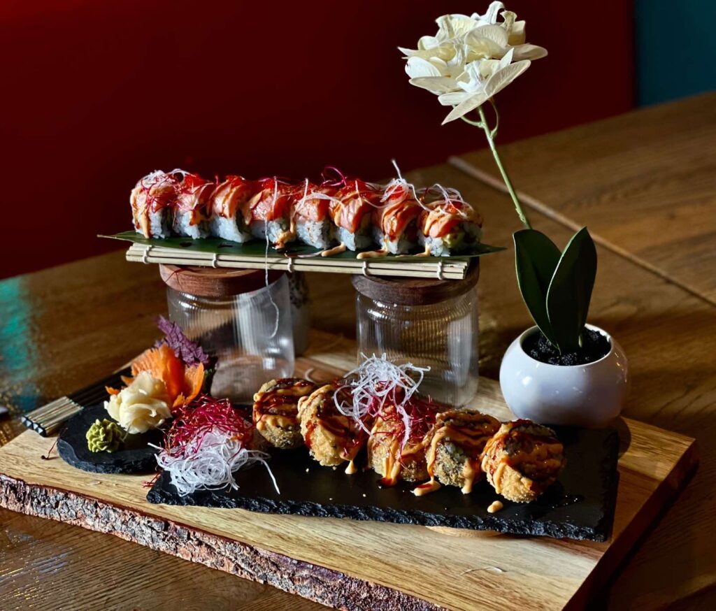 Elegante Sushi-Anordnung auf Holzbrett mit Blüte, moderne Präsentation