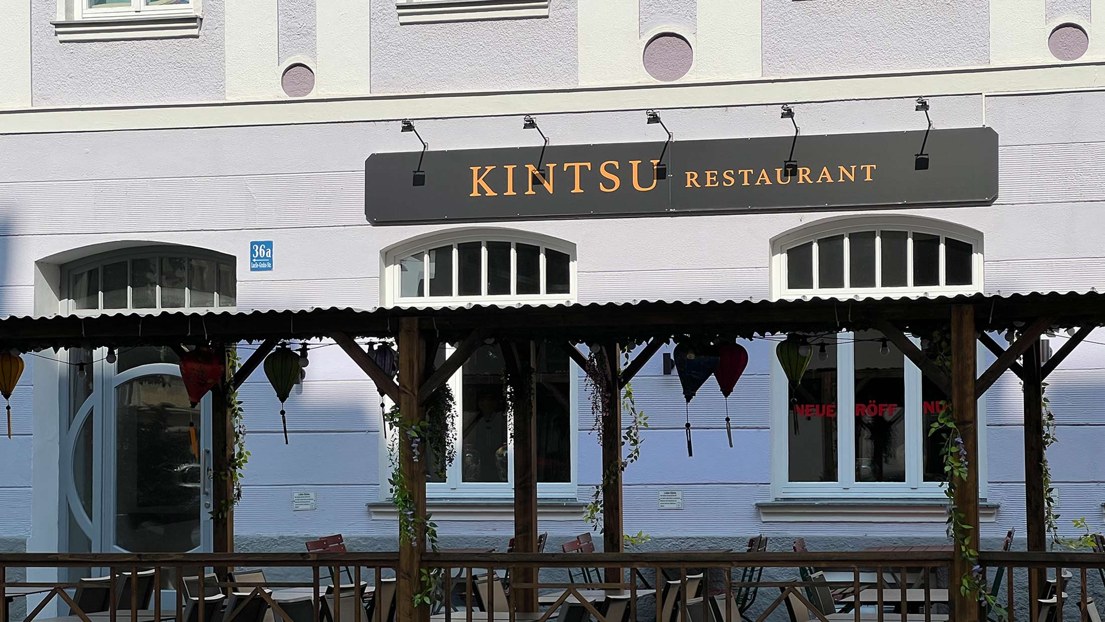 Ein lilafarbenes Gebäude mit einem Kintsu Restaurant-Schild und einer Veranda.