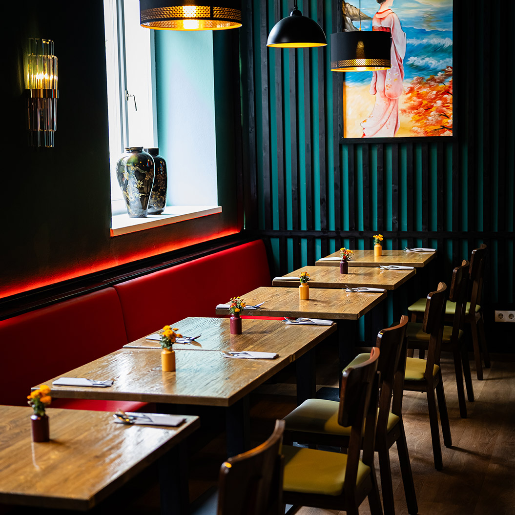 Ein modern eingerichtetes Restaurant mit Holztischen und bunten Blumenvasen