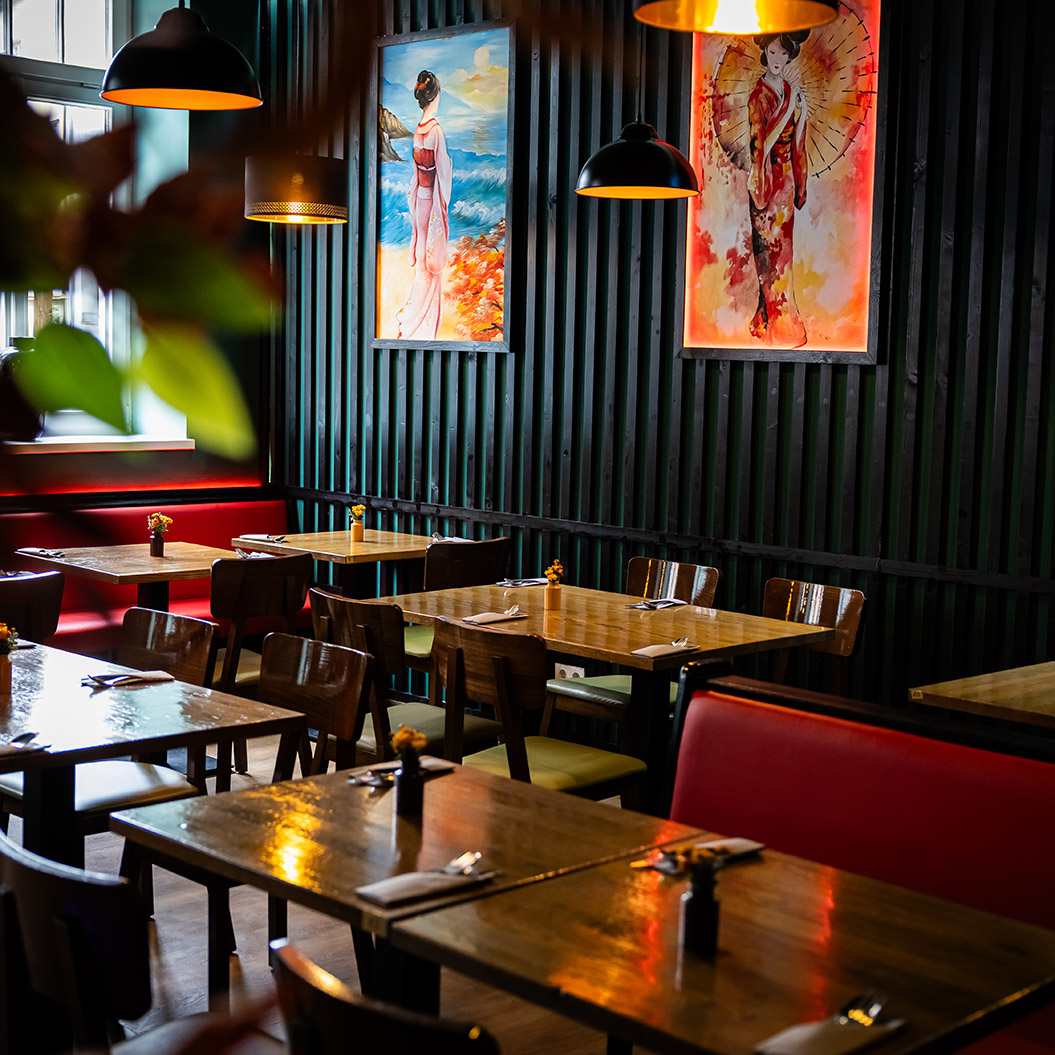 Gemütliches Restaurant mit hölzernen Tischen, bunten Gemälden und warmem Licht